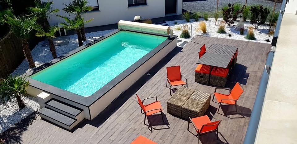 Piscine entourée d’une terrasse et d’un jardin paysager