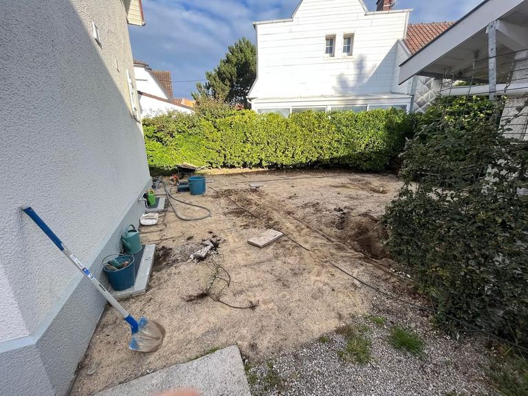 Avant : La cour arrière terrassée puis pavée, avec caniveau.