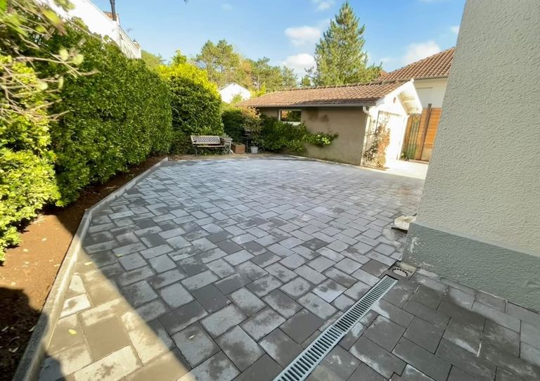 Après : La cour arrière terrassée puis pavée, avec caniveau.