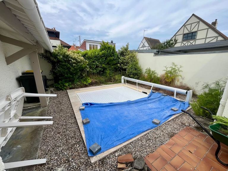 Avant : Les abords d’une piscine repris en dalles grès cérame, clôture bois neuve.